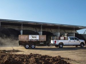 separated dirt piles and a white pick up truck with Terra advertisement on side